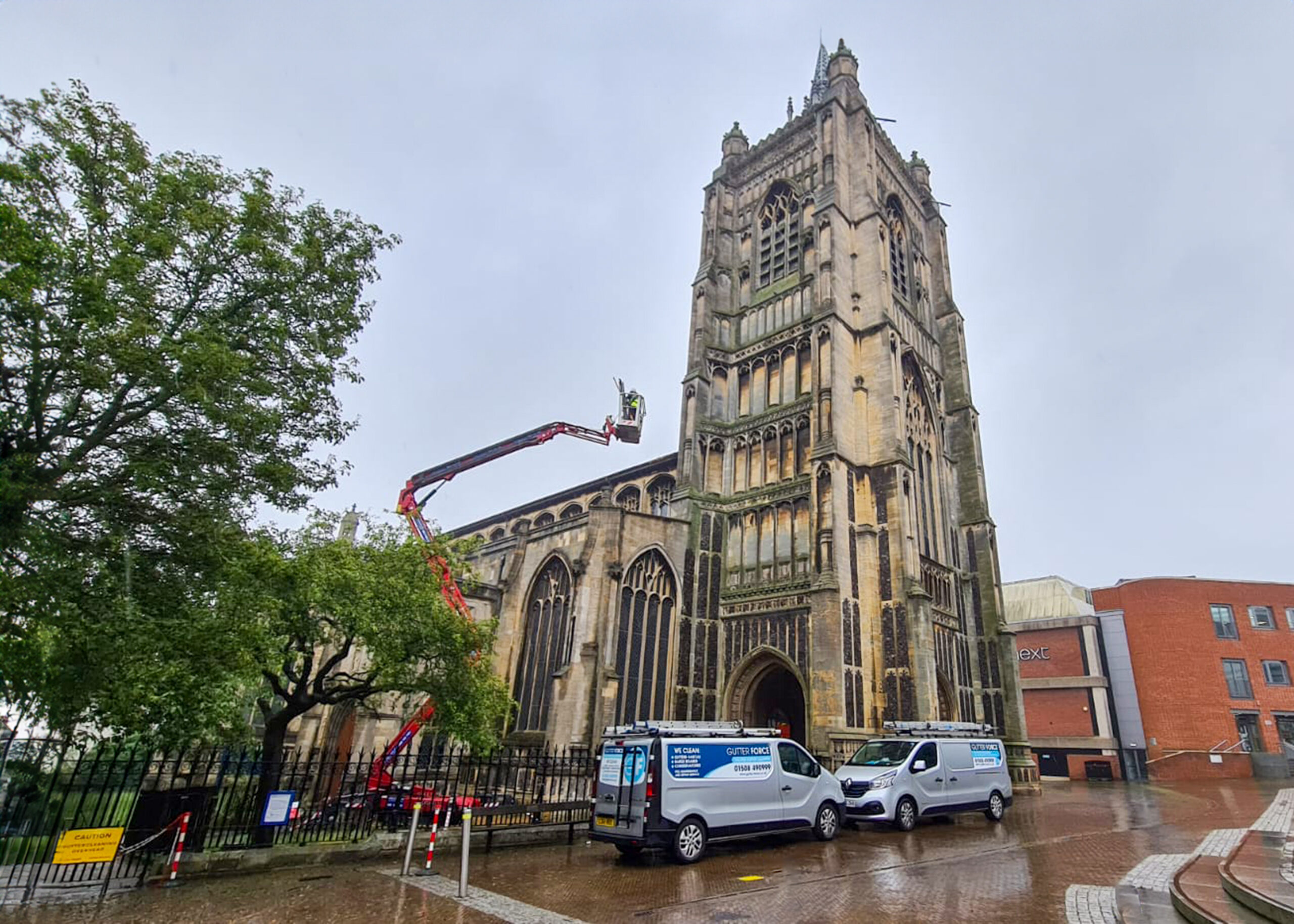 G Force team using a cherry picker to clean the top of a cathedral.